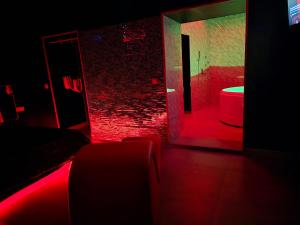 Habitación oscura con baño con luces rojas y aseo. en Parque erotico, en Jerez de la Frontera