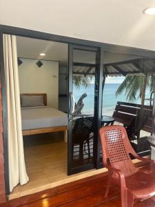 a bedroom with a bed and a view of the ocean at Pimmada Hut in Haad Pleayleam