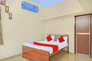 KhāpriにあるHotel O Krishna Villaのベッドルーム1室(赤い枕のベッド1台付)