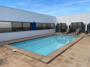 a swimming pool on top of a building at Flat Residence Campinas in Campinas