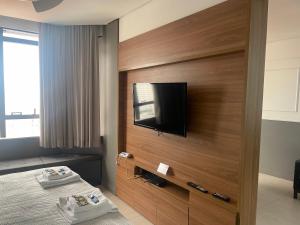 a hotel room with a flat screen tv on a wall at Flat Residence Campinas in Campinas
