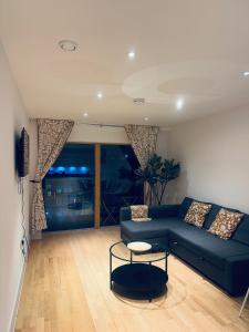 a living room with a blue couch and a table at Modern and Spacious 2 bedroom Flat in Streatham in London