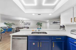 a kitchen with blue cabinets and a sink at Ground Floor Beachfront 2 Steps From Amenities IV in South Padre Island