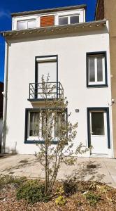 une maison blanche avec un arbre devant dans l'établissement Villa Ninon Le Touquet, à Le Touquet-Paris-Plage