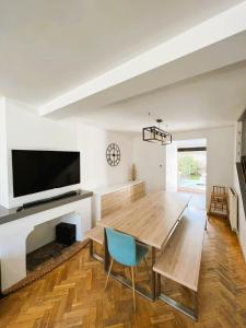 une salle à manger avec une table en bois et une télévision dans l'établissement Villa Ninon Le Touquet, à Le Touquet-Paris-Plage