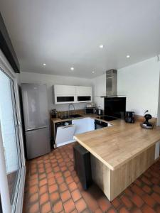 une cuisine avec un grand îlot en bois au milieu dans l'établissement Villa Ninon Le Touquet, à Le Touquet-Paris-Plage