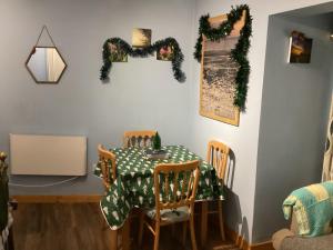 a dining room table and chairs with a green and white tablecloth at New Inn Lodge in East Dereham