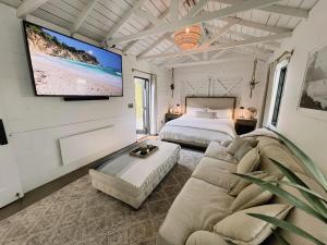 a bedroom with a couch and a tv on the wall at Channel Islands Beach Retreat in Oxnard