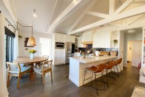 a kitchen with white cabinets and a table and chairs at NiDOMARE - Channel Islands Beach Retreat in Oxnard