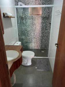 インビトゥバにあるMarina do Rosaのトイレとガラスのシャワー付きのバスルーム