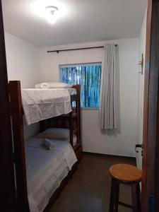 インビトゥバにあるMarina do Rosaの小さな客室で、二段ベッド2台、スツールが備わります。