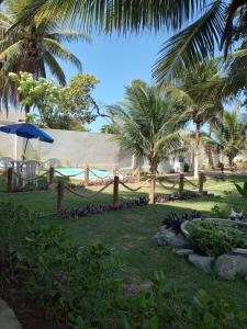 un complejo con hamaca y palmeras en Casa charmosa a beira mar, en Paulista