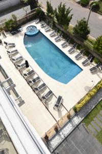 an overhead view of a swimming pool with lounge chairs and a pool at La Mirage in Villa Gesell +3 photos