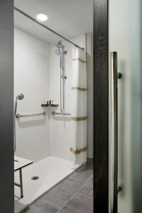 a bathroom with a shower with a shower curtain at Marriott Cincinnati Northeast in Mason