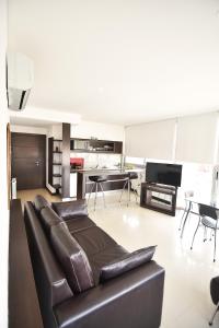 a living room with a leather couch and a table at La Mirage in Villa Gesell