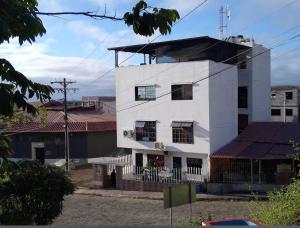 a white building with a black roof at Casa Rentera D Elías 5 in Puerto Baquerizo Moreno