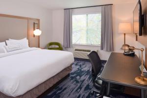 a hotel room with a bed and a desk and a window at Fairfield Inn & Suites by Marriott Pittsburgh New Stanton in New Stanton +19 photos