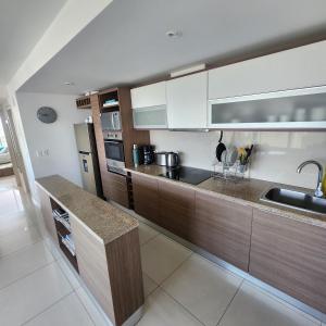 a kitchen with wooden cabinets and a counter top at Gala Vista in Punta del Este