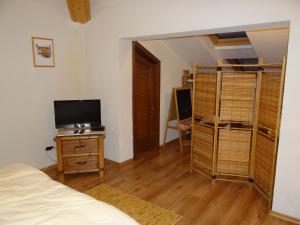 Un dormitorio con una cama y un escritorio con televisión. en Pensiunea Bamboo - Villa, en Breaza