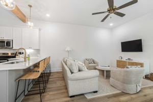 Una cocina y una sala de estar con un sofá y una mesa. en New cottage near Sports Complex with King Beds, en Youngsville