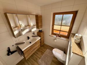 a bathroom with a sink and a toilet and a mirror at Haus Hochlenzerblick in Schönau am Königssee +48 photos
