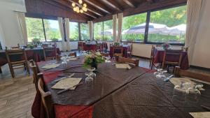 a dining room with a long table and chairs at Hotel del Lago Ampollino in Torre Caprara