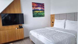 a bedroom with a bed and a flat screen tv at Jane's Resort Studio by Tatralandia & Lake in Liptovský Mikuláš