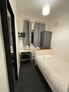 a small room with a bed and a small table at Sidcup Stay in Sidcup