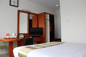 Un pat sau paturi într-o cameră la Hotel Grand Karawang Indah