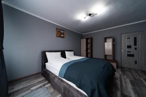 a bedroom with a large bed with a blue blanket at Szilárd Apartment in Miercurea-Ciuc
