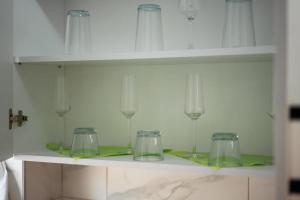 a shelf with glasses and wine glasses on it at Szilárd Apartment in Miercurea-Ciuc +69 photos