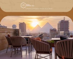 een balkon met stoelen en uitzicht op de piramides bij Mirage pyramids view hotel in Caïro