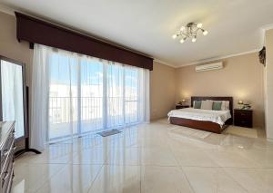 a large bedroom with a bed and large windows at Jacuzzi Terrace Getaway with Valletta Views in Sliema