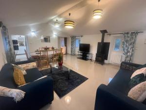 a living room with two blue couches and a table at Haut villa Les Tilleuls 95 m2 7 pers in Carros