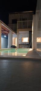 a view of a swimming pool at night at casa por temporada pontal da barra in Maceió +29 photos