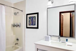 a white bathroom with a sink and a mirror at Four Points by Sheraton Surrey in Surrey +18 photos