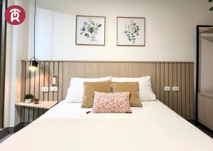 a bedroom with a white bed with a wooden headboard at Reset (Hotel-Cafe-Coworking) in Cali +25 photos