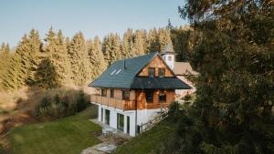 una casa con techo verde en una colina en Drevenica pod Zvonicou, en Demänovská Dolina