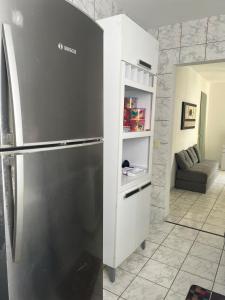 a kitchen with a stainless steel refrigerator in a room at Cantinho aos pés do Ibituruna in Governador Valadares