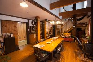 a large dining room with a wooden table and chairs at Pension Jokura in Hakodate