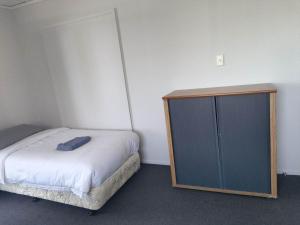 1 dormitorio pequeño con 1 cama y armario en 4 Beds including 1 Double Bed, 1 Single Beds, 2 Double Sofa Beds, Suite 2, 37 Totara Avenue, New Lynn, en Auckland