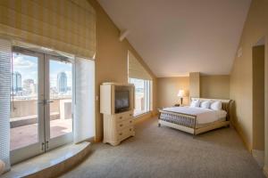 a bedroom with a bed and a tv and a window at Cincinnati Marriott at RiverCenter in Covington