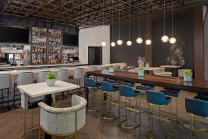 a restaurant with tables and chairs and a bar at Cincinnati Marriott at RiverCenter in Covington