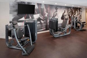 a gym with three tread machines and a tv at Cincinnati Marriott at RiverCenter in Covington