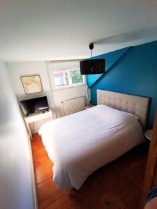 une chambre avec un lit blanc avec un mur bleu dans l'établissement Villa Ninon Le Touquet, à Le Touquet-Paris-Plage 10 autres photos