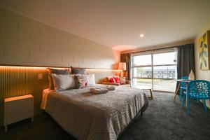 a bedroom with a bed with a large window at Starlight Lakeview Vista - 5BR Hideaway & Hot Tub in Lake Tekapo