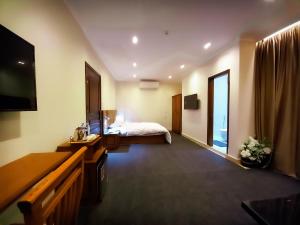 a hotel room with a bed and a television at Al Saraya Hotel Bani Sweif in Banī ‘Aţīyah