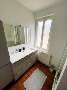 une salle de bain blanche avec un lavabo et un miroir dans l'établissement Villa Ninon Le Touquet, à Le Touquet-Paris-Plage