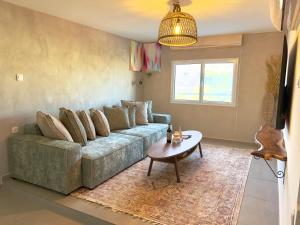 埃拉特אשראם-Ashram Eilat的客厅里有一张沙发和一张桌子。