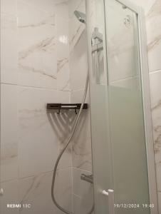 una ducha con puerta de cristal en un baño en Beau studio propre, en Colombes